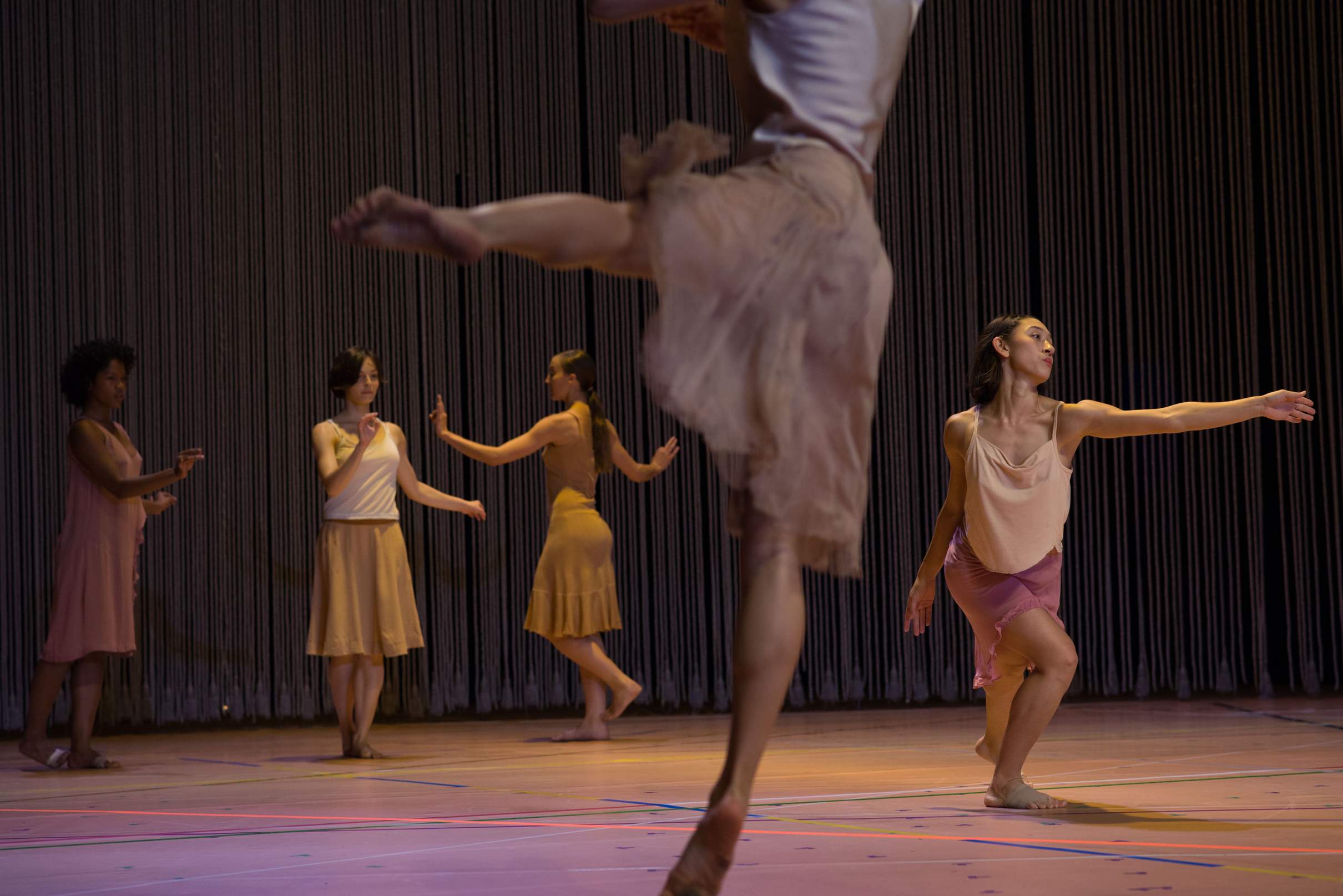 Five dancers perform, some holding their hands in detailed poses with distinctive mannerisms.